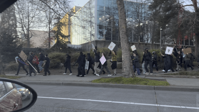 Protest outside of the space needle. Some are holding signs that say no one is illegal others are chanting housing is a human right.