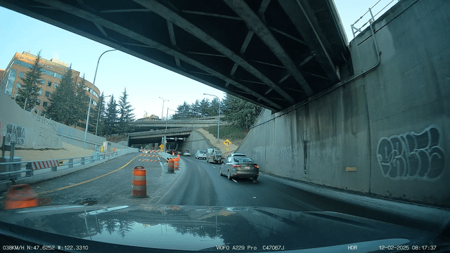 Use both lanes and do a zipper-merge, don’t be an a**hole and slow down traffic