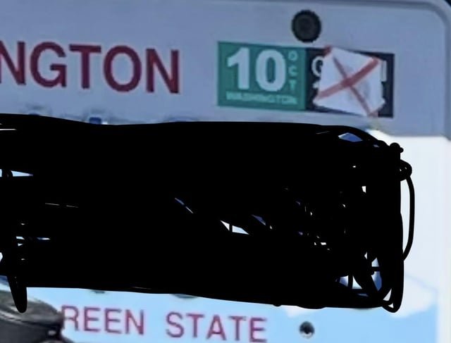 someone put a sticker X over old car tab