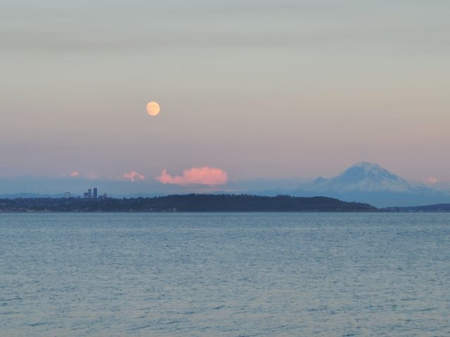 Moonrise over the city and mountain Tuesday