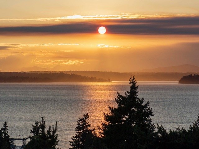 WEST SEATTLE SUNSET: Smoke-framed setting sun