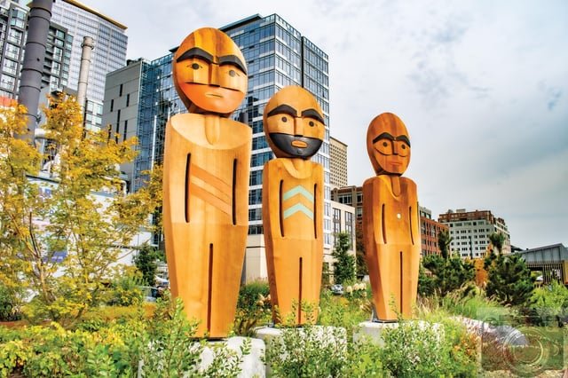 Family on the waterfront. New installation of carved and painted cedar sculptures, standing ten to twelve feet tall, near Pier 58 by noted Coast Salish artist and Puyallup tribal member Qwalsius-Shaun Peterson: