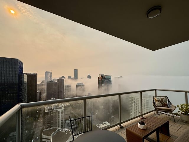 Watching the fog swallow our city under the orange sun