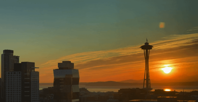 A sunset gives way to the Space Needle in blue.