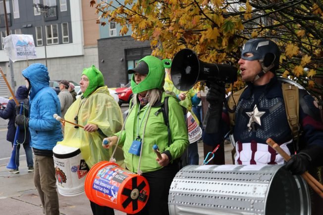 Captain America, handmaids, and hope: What happened at first of West Seattle’s two ‘We Ain’t Buying It’ demonstrations