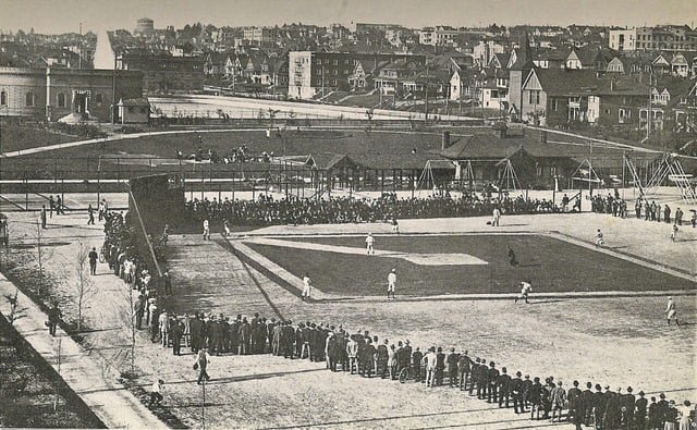 Baseball at Lincoln Park, today called Cal Anderson, circa 1919. The open-air Lincoln Reservoir is visible in the near background. The building at left still exists today, as does the German United Church of Christ at right. The water tower on the horizon is in Volunteer Park.