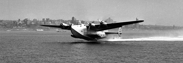 Golden Age of Flight. Test pilot Eddie Allen flies Boeing 314 NX18601 Clipper on its first flight, June 7, 1938, off Elliott Bay and remained aloft for 38 minutes. The Clipper had a wingspan of 152 feet, length of 106 feet, and a gross weight of 84,000 lbs. The flying boat had a range of 5,200 miles