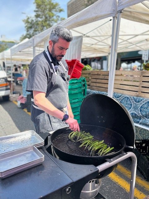 HAPPENING NOW: Local restaurateur’s cooking demo at West Seattle Farmers’ Market
