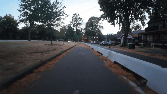 Person blowing their leaves into protected bike lane on Ravenna