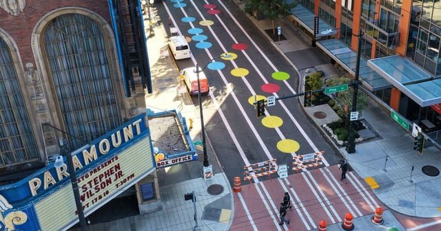 35 circles and 5 thick white lines are painted on this downtown street. It won’t come off
