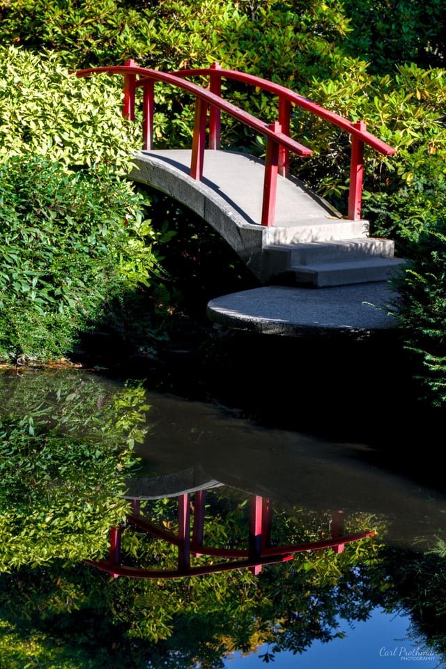 Moon Bridge reflected in a still pond at Kubota Garden, Seattle