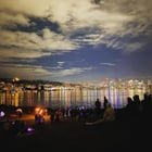 Gas Works Park after dark — fire spinners on the hill, skyline across Lake Union